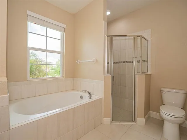 a bathroom with a tub a sink and a large mirror