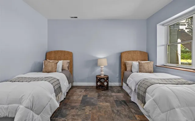 a bedroom with a bed a window and lamp