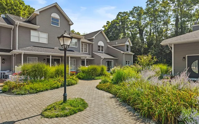 a front view of a house with a garden and plants