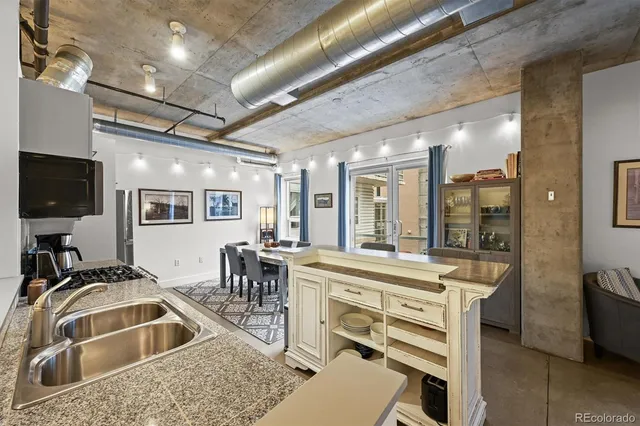 a kitchen with a stove a sink a dining table and chairs