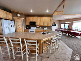 1940 East Shore Road St. Charles, ID 83272 - Photo 17 of 64 Kitchen with white appliances, a kitchen bar, light countertops, light tile patterned floors, and crown molding