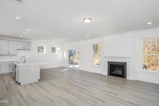 a large kitchen with a wooden floor and white stainless steel appliances