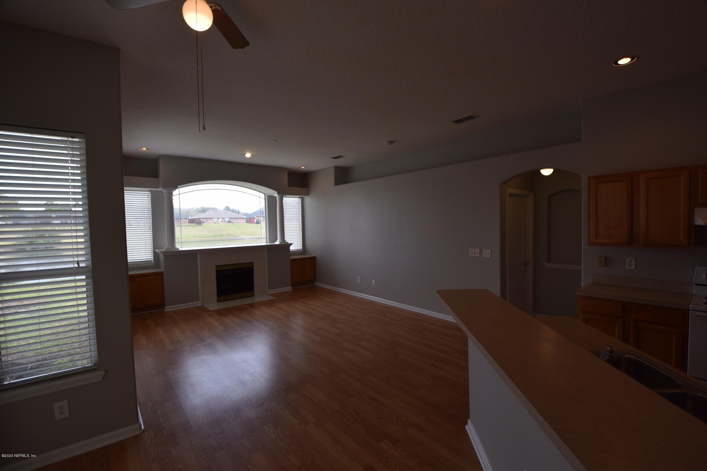 2473 Shelby Creek Road West Jacksonville, FL 32221 - Photo 5 of 9 an empty room with wooden floor cabinet and windows