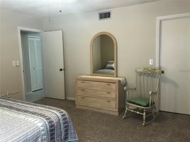 a living room with furniture a rug and a floor to ceiling window