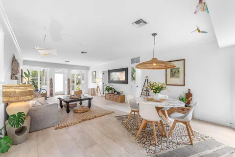a dining room with furniture a chandelier and wooden floor
