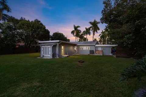 a view of a house with backyard sitting area and garden