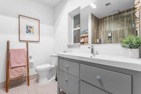 a bathroom with a sink toilet and a mirror