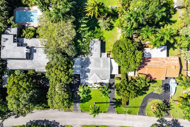 an aerial view of a house with a yard and large trees