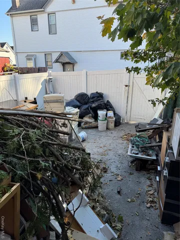 a view of a backyard with chairs and potted plants