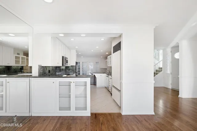 a open kitchen with white cabinets and stainless steel appliances