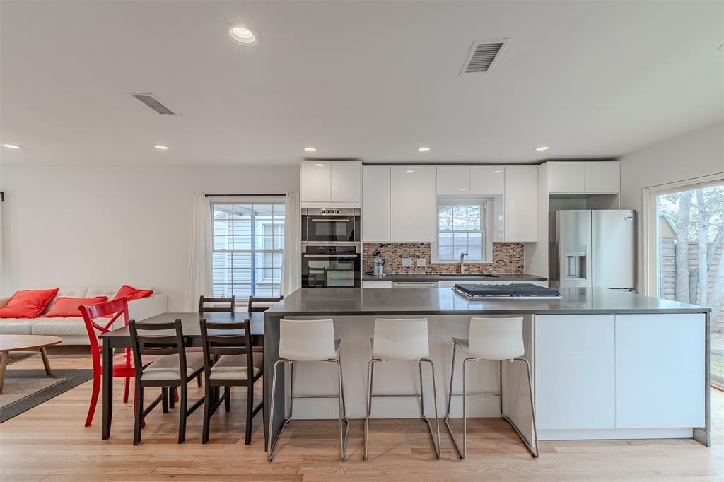 8927 Diceman Drive Dallas, TX 75218 - Photo 3 of 33 a kitchen with stainless steel appliances kitchen island granite countertop a table and chairs in it