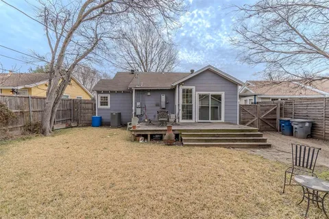 a view of a house with a patio and wooden fence