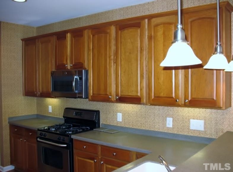 5328 Shaker Heights Lane Raleigh, NC 27613 - Photo 11 of 25 a kitchen with stainless steel appliances a stove a sink and a microwave