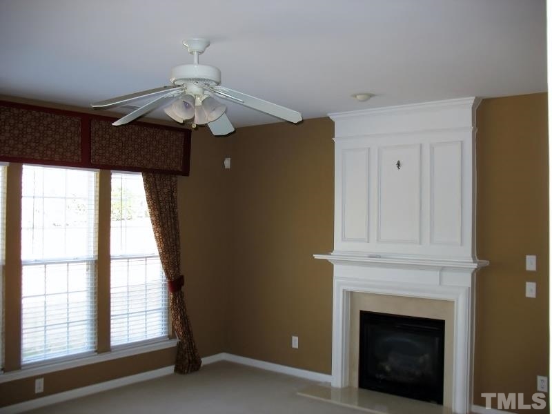 5328 Shaker Heights Lane Raleigh, NC 27613 - Photo 16 of 25 a chandelier fan and a fireplace in a room
