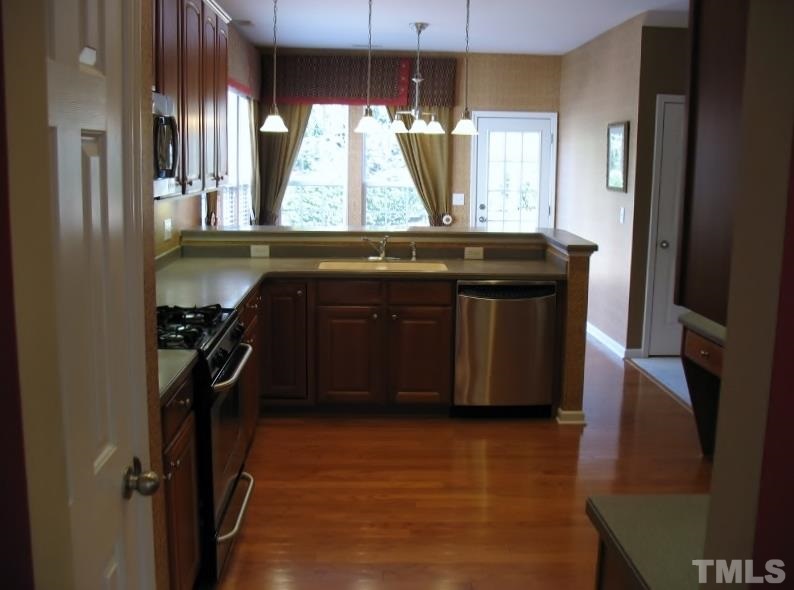 5328 Shaker Heights Lane Raleigh, NC 27613 - Photo 9 of 25 a kitchen with a sink a stove cabinets and a refrigerator
