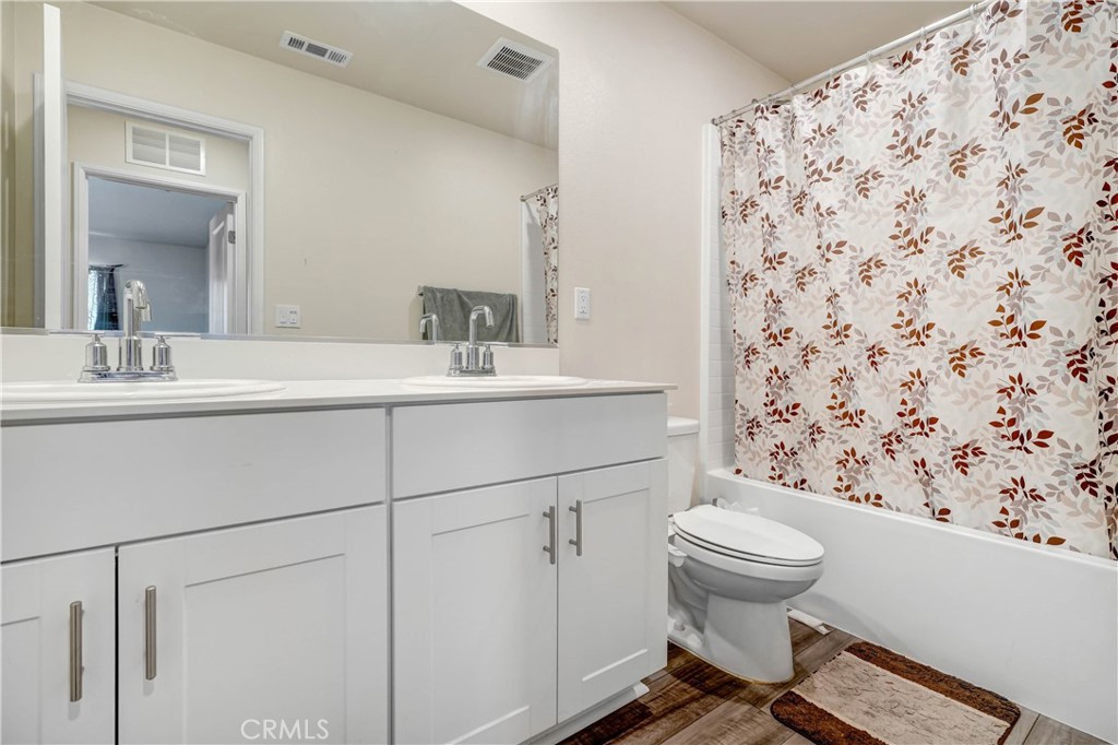 24871 Tiger Avenue Moreno Valley, CA 92551 - Photo 11 of 13 a bathroom with a sink toilet and mirror
