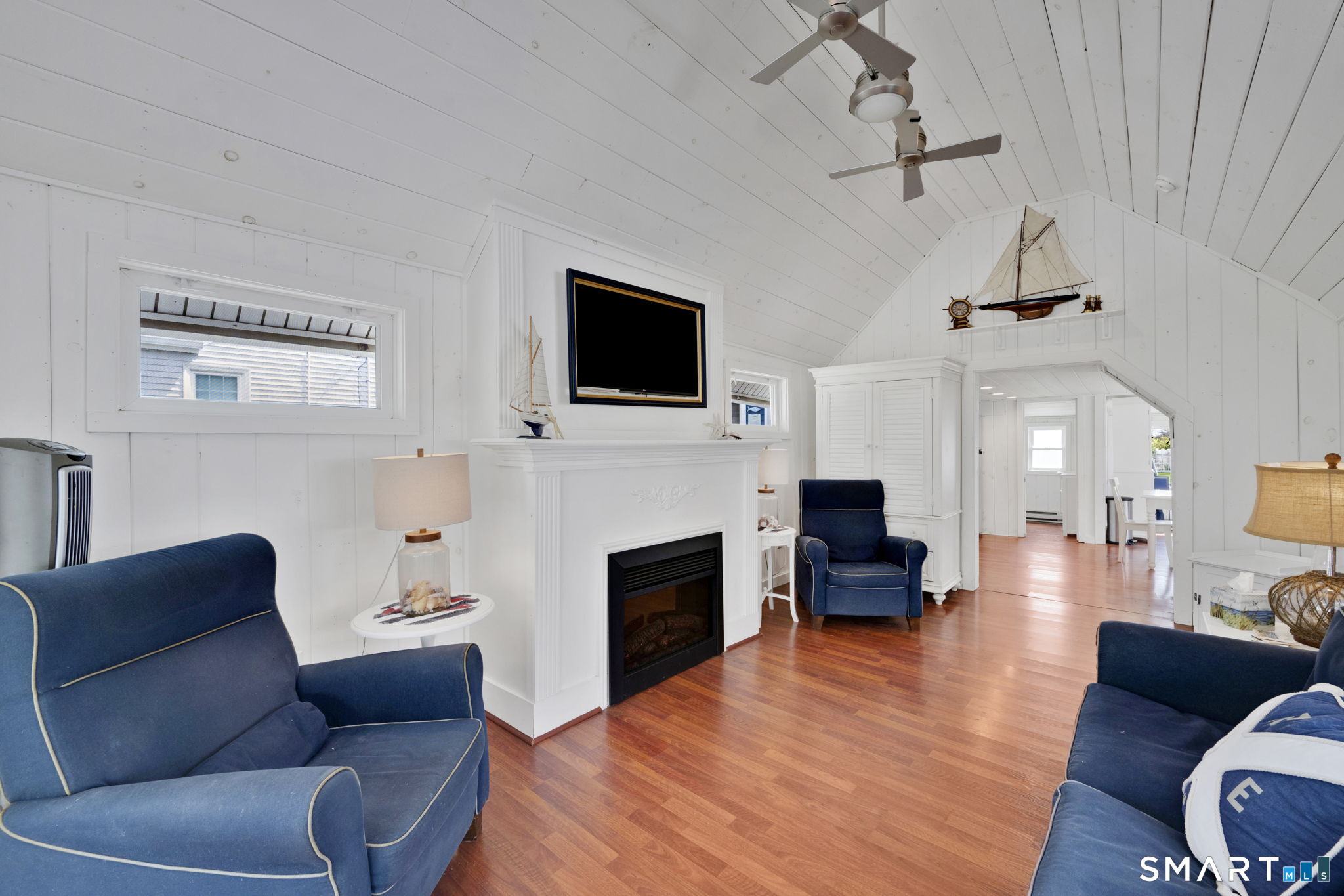 96 Chalker Beach Road Old Saybrook, CT 06475 - Photo 24 of 33 a living room with furniture a flat screen tv and a fireplace