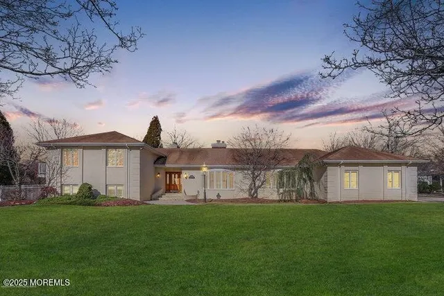 a view of a house with a big yard and large trees