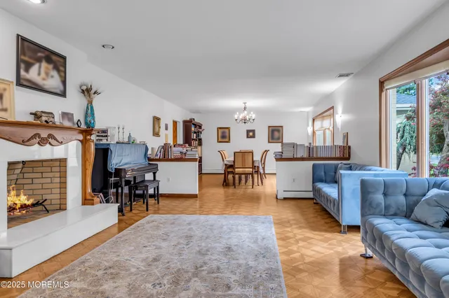 a living room with furniture and a dining table with kitchen view