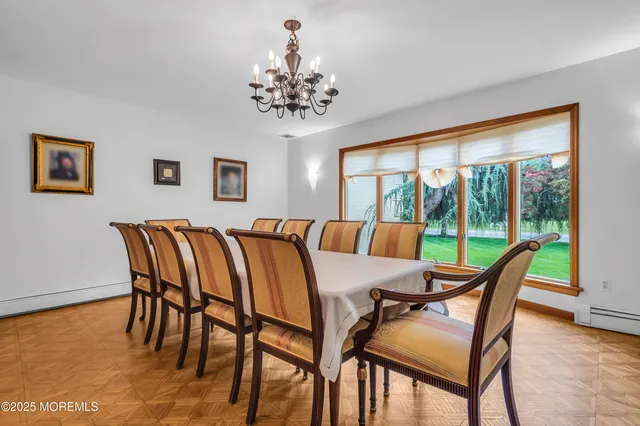 a dining room with furniture a large window and a chandelier
