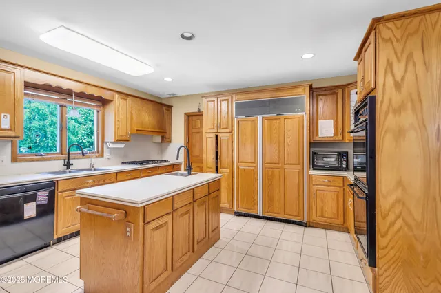 a kitchen that has a sink a stove top oven a refrigerator and a cabinets