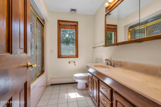 a bathroom with a granite countertop sink a toilet and a mirror