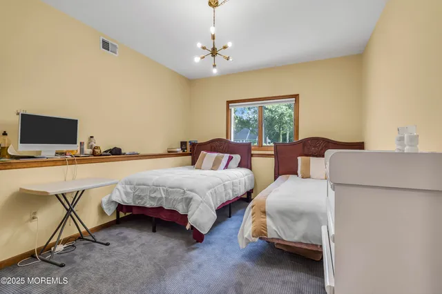 a spacious bedroom with two beds and a window