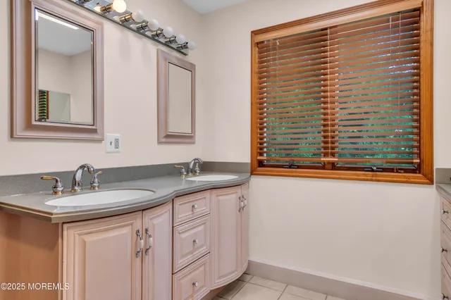 a bathroom with a granite countertop sink and a window