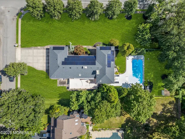 an aerial view of a house with garden space and a car parked