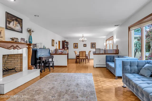 a living room with furniture and a dining table next to a window