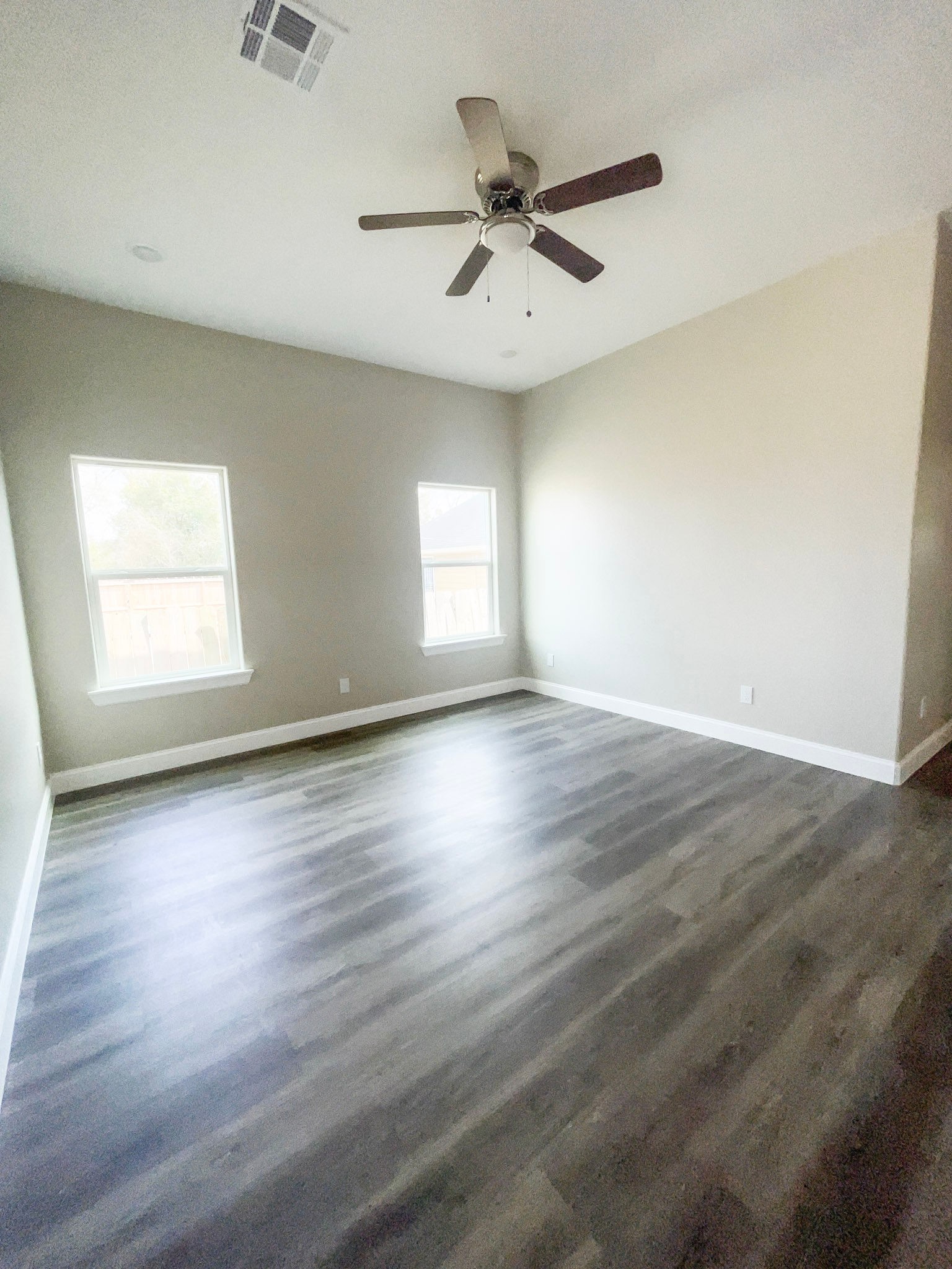 8309 Parker Road, Unit A Houston, TX 77078 - Photo 10 of 10 an empty room with wooden floor fan and windows
