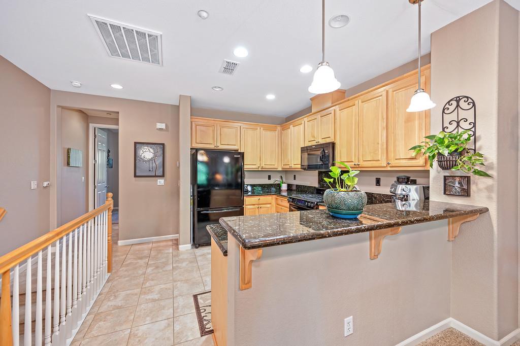 2603 Las Palomas Loop Lincoln, CA 95648 - Photo 9 of 22 a kitchen with stainless steel appliances granite countertop a refrigerator a sink a stove and a wooden cabinets