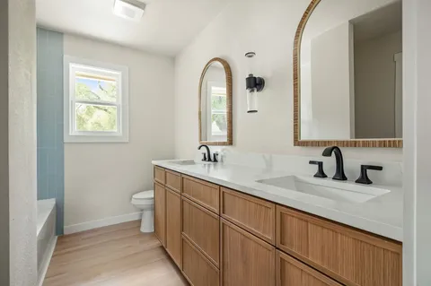 a bathroom with a granite countertop sink a toilet and a mirror