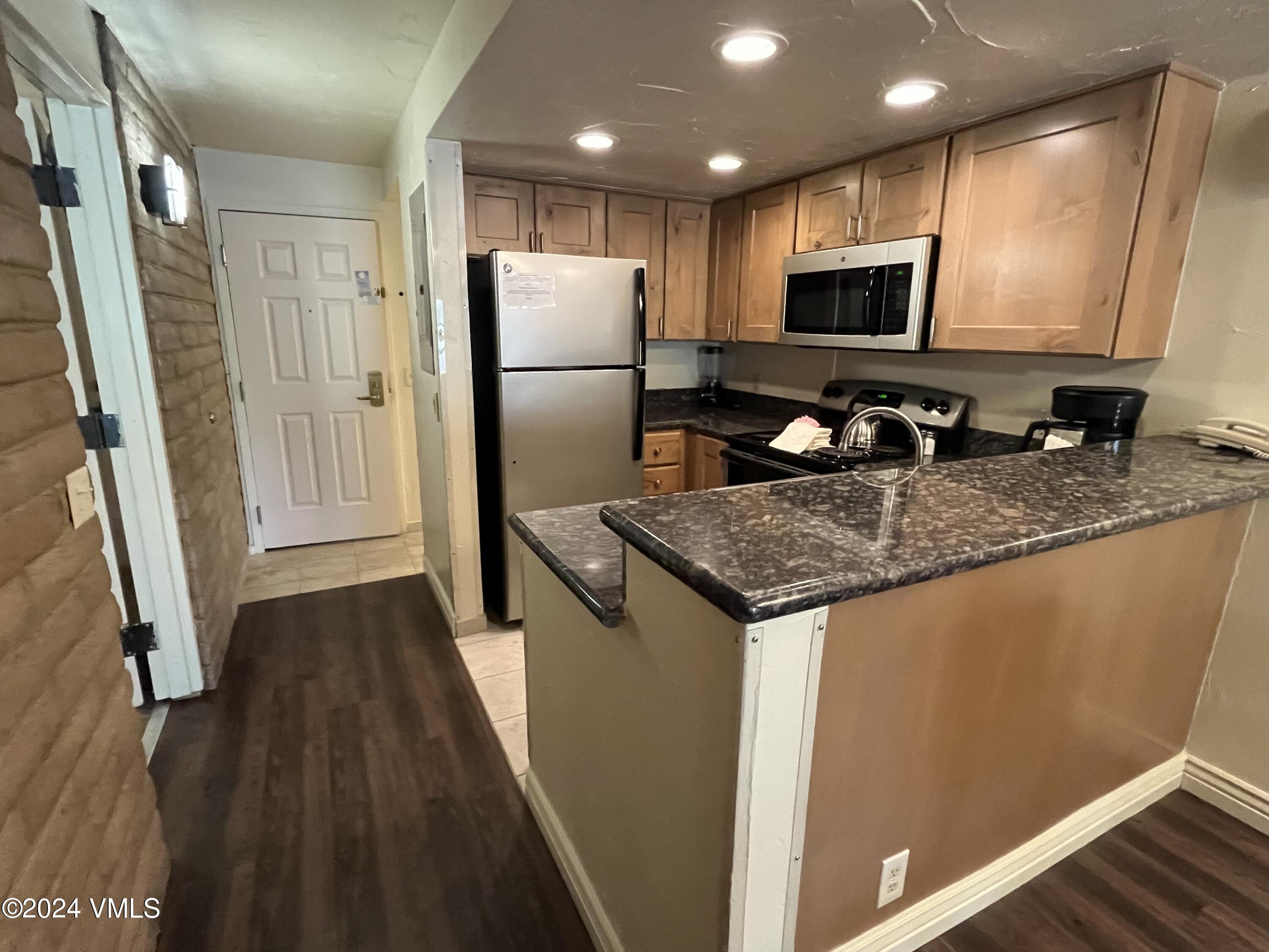 1020 Vail View Drive, Unit 340241 Vail, CO 81657 - Photo 1 of 32 a kitchen with granite countertop a refrigerator a sink a stove a microwave and island