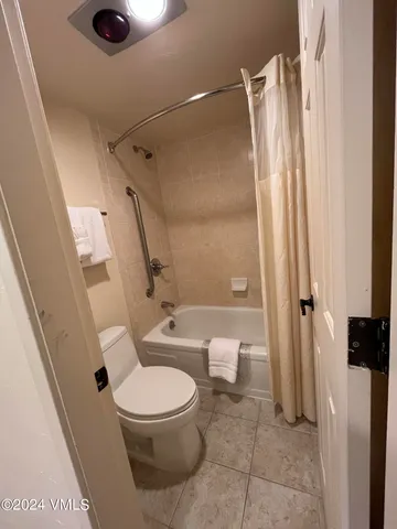 a white toilet sitting next to a bathroom sink and a shower