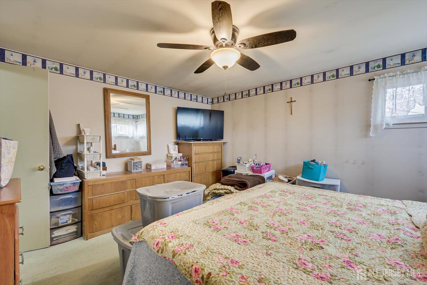 44 McKinley Avenue Colonia, NJ 07067 - Photo 22 of 38 a bedroom with a bed a chandelier and dresser