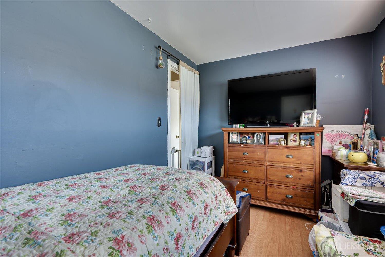 44 McKinley Avenue Colonia, NJ 07067 - Photo 24 of 38 a bedroom with a bed and flat tv screen on the dresser