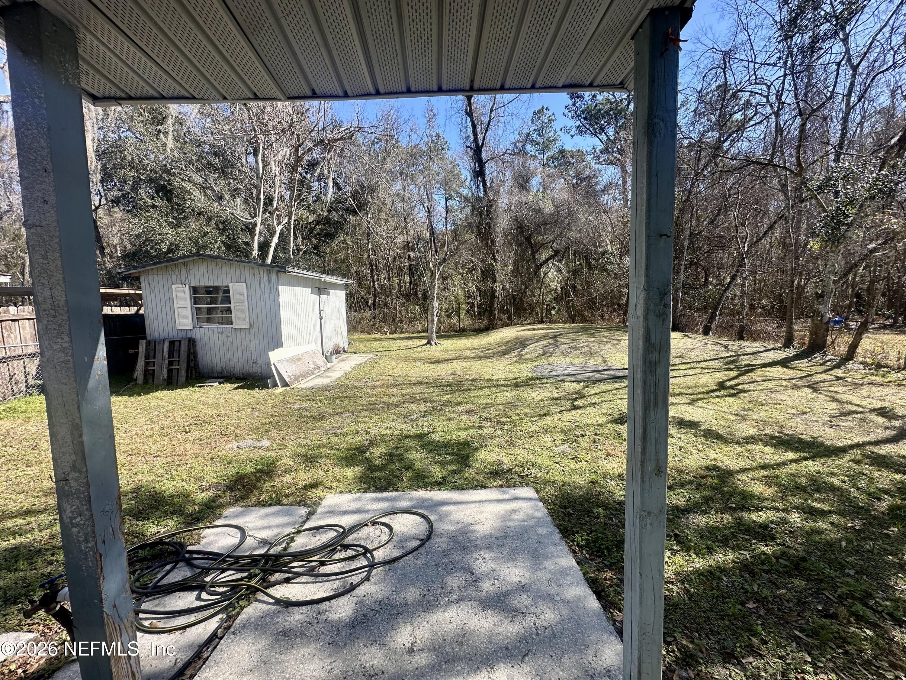 11335 Wingate Road North Jacksonville, FL 32218 - Photo 15 of 17 a view of a backyard with table and chairs under an umbrella