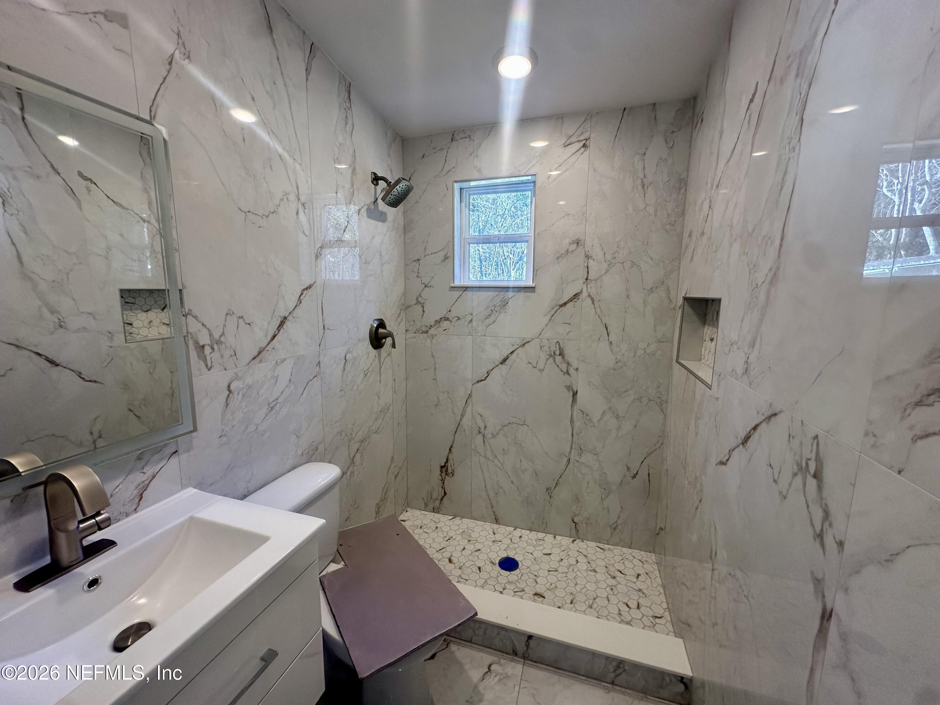 11335 Wingate Road North Jacksonville, FL 32218 - Photo 9 of 17 a bathroom with a sink shower and a mirror