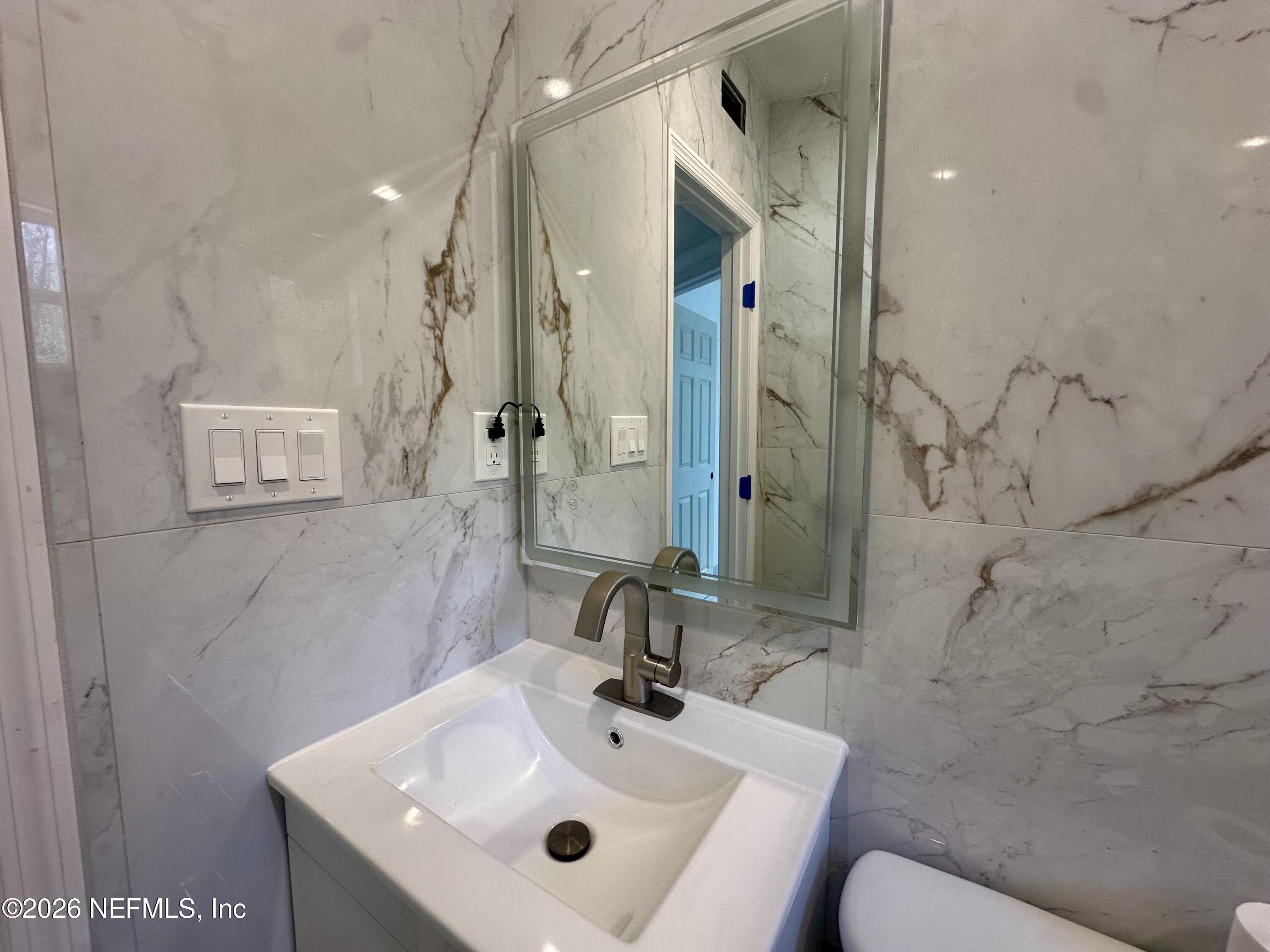 11335 Wingate Road North Jacksonville, FL 32218 - Photo 10 of 17 a bathroom with a sink and a mirror