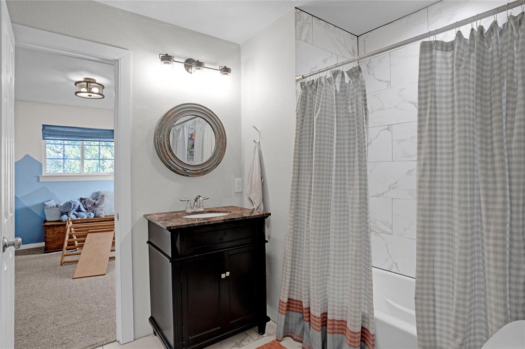 7070 Armadillo Rdg Road McKinney, TX 75071 - Photo 21 of 34 a bathroom with a sink a mirror and a shower curtain