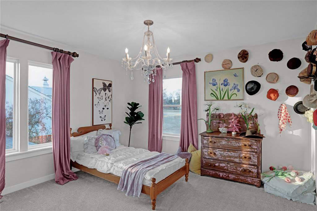 7070 Armadillo Rdg Road McKinney, TX 75071 - Photo 23 of 34 a bedroom with a bed and a chandelier