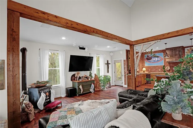 a bedroom with furniture a flat screen tv and a window