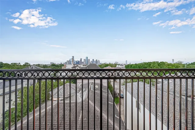 a view of a balcony with wooden floor & fence
