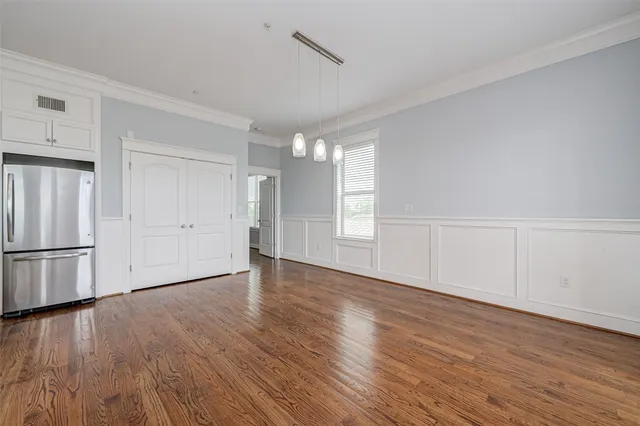 a view of empty room with wooden floor and window
