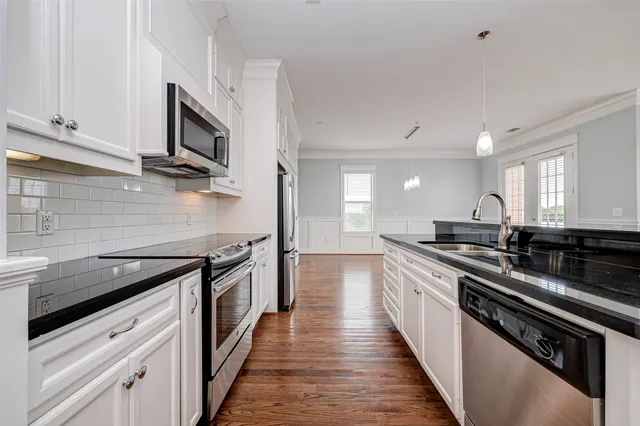 a kitchen with stainless steel appliances a sink dishwasher stove and oven