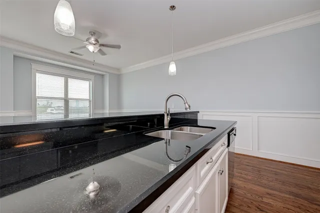 a kitchen with a sink and wooden floor