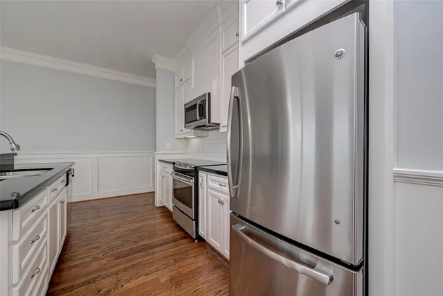 a kitchen with granite countertop a refrigerator stove and oven