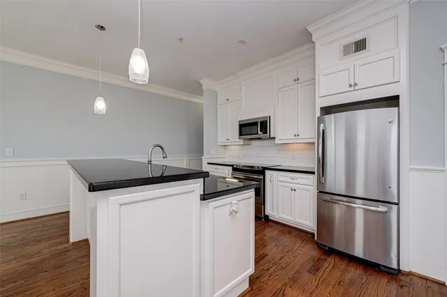 a kitchen with granite countertop a sink stove and refrigerator