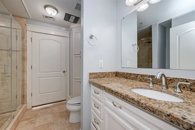 a bathroom with a granite countertop sink toilet and shower